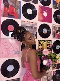 a woman laying on a pink floor with a bunch of records